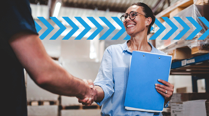 A smiling woman holding a blue clipboard shakes hands with another person in a warehouse setting, with blue arrows overlayed in the background—perfect for illustrating logistics or 3PL companies in action.