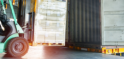 A forklift from SpeedShip efficiently loads a large pallet of boxes into a shipping container inside the warehouse. Sunlight filters through, casting a warm glow on the bustling scene.