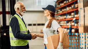 An older man in a safety vest and a younger woman in a cap with a package shake hands in a warehouse. The warehouse has shelves filled with boxes. The woman is wearing a gray T-shirt and gloves. Blue arrow graphics are visible on the right side.