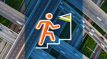 Overhead view of a multi-lane highway interchange with cars. Superimposed is an icon of an orange figure climbing stairs toward a green flag, symbolizing progress or achievement.