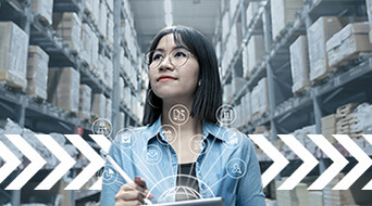 A person with glasses stands in a warehouse surrounded by tall stacks of boxes. They hold a tablet and appear focused. Overlaid icons represent technology and logistics, with arrows pointing forward, suggesting progress.
