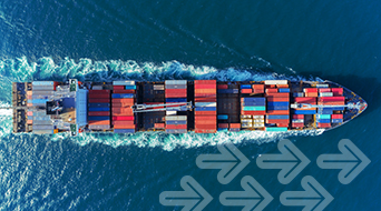 Aerial view of a large cargo ship carrying multicolored shipping containers moving through the ocean. The water is deep blue with a visible wake. Several translucent arrows are overlaid, pointing forward, suggesting movement.