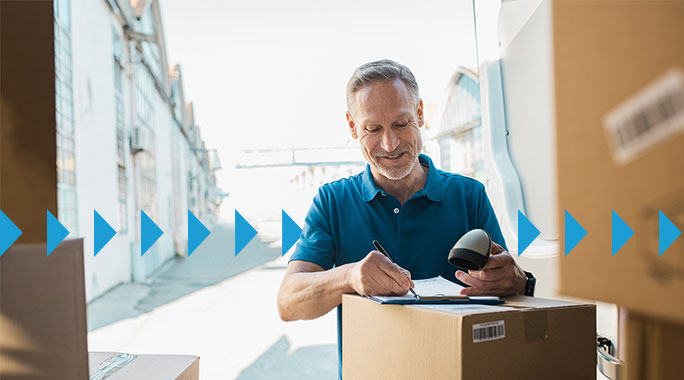 A man in a blue polo shirt stands outside by a delivery van, smiling as he signs a document on a clipboard. Surrounded by boxes, hes clearly the Shipper of Choice. A row of blue arrows overlays the image diagonally, adding to the dynamic scene.