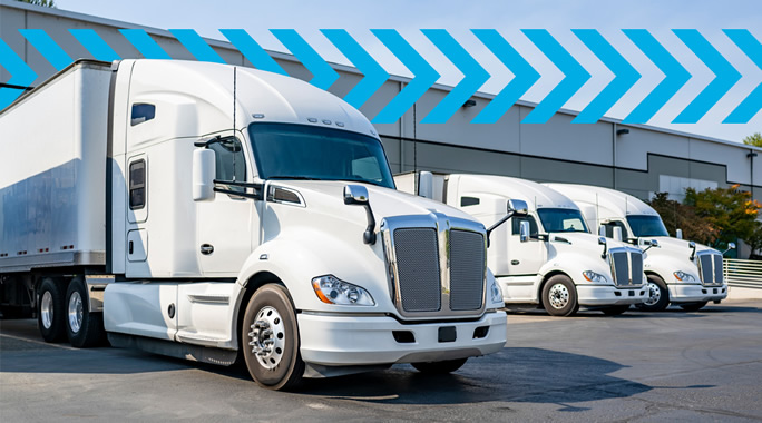 A row of three white semi-trailer trucks parked in front of a large warehouse. The image features blue diagonal arrows above the trucks, suggesting motion or progress. The sky is clear and sunny.