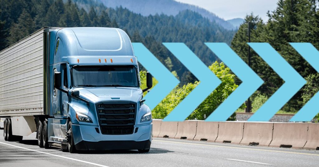 A blue semi-truck driving on a highway, surrounded by lush green trees and distant mountains. Large blue arrows are overlaid pointing to the right, suggesting motion or direction.