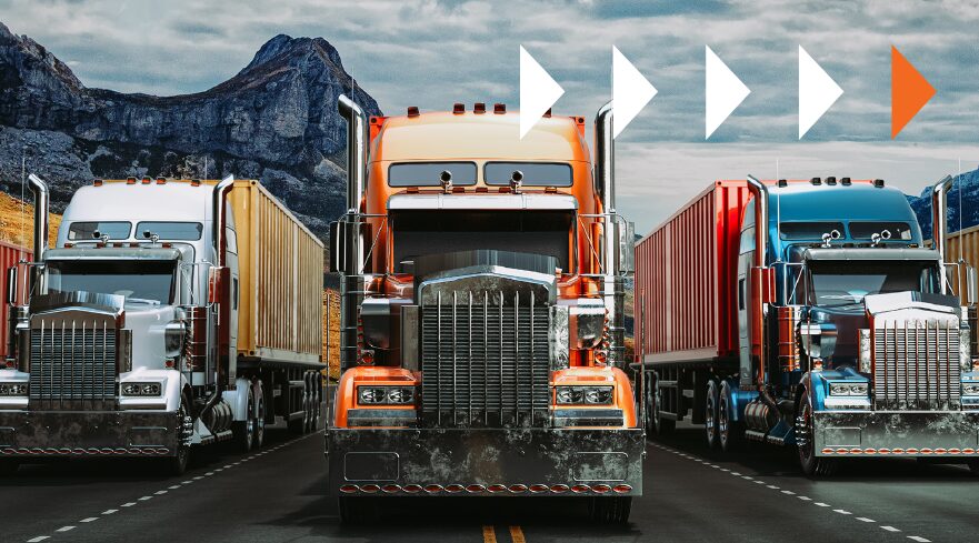 Three large trucks in white, orange, and blue are lined up on a road with mountains in the background, perfectly illustrating the latest logistics trends. Above them, white and orange arrow symbols point to the right against a cloudy sky.